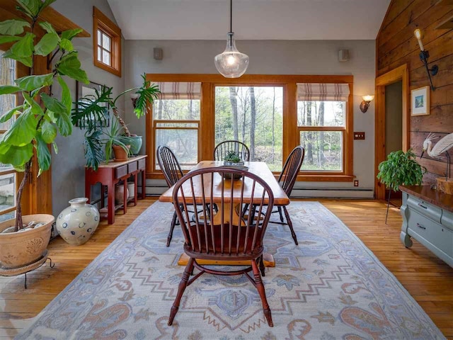 7671 Hoyt Rd, Harbor Springs, MI 49740 - dining area with a baseboard radiator, light wood finished floors, and plenty of natural light
