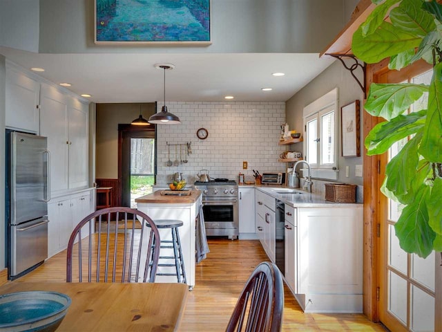 7671 Hoyt Rd, Harbor Springs, MI 49740 - kitchen featuring stainless steel appliances, open shelves, a sink, white cabinets, and light wood finished floors