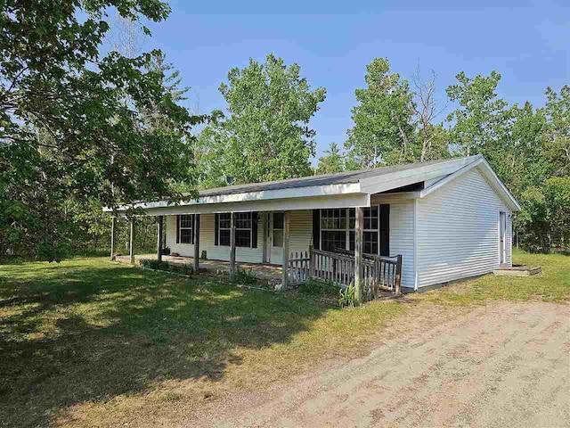 394 Townline Rd, Pellston, MI 49769 - single story home with covered porch, a front lawn, and dirt driveway