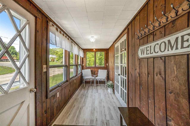 5791 Lebaron St, Levering, MI 49755 - unfurnished sunroom with wood finished floors, healthy amount of natural light, wood walls, and french doors
