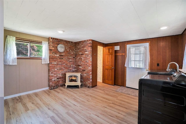5791 Lebaron St, Levering, MI 49755 - interior space with light wood-type flooring, baseboards, a sink, wooden walls, and a wood stove