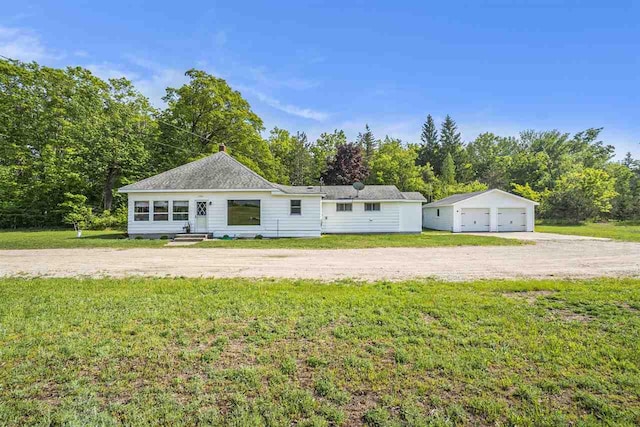 5791 Lebaron St, Levering, MI 49755 - view of front of house featuring a detached garage, an outdoor structure, and a front lawn