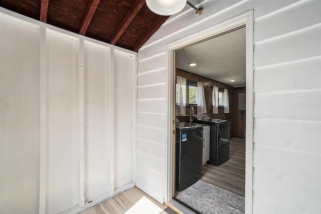 5791 Lebaron St, Levering, MI 49755 - interior space featuring washing machine and clothes dryer, light wood-style flooring, and vaulted ceiling