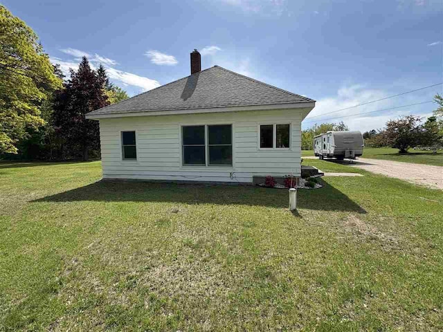 5791 Lebaron St, Levering, MI 49755 - rear view of property featuring roof with shingles, a yard, and a chimney