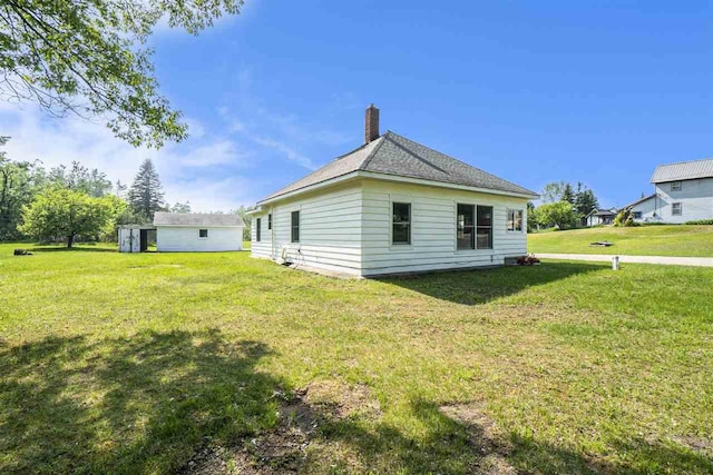 5791 Lebaron St, Levering, MI 49755 - rear view of house with a chimney, a yard, and an outbuilding