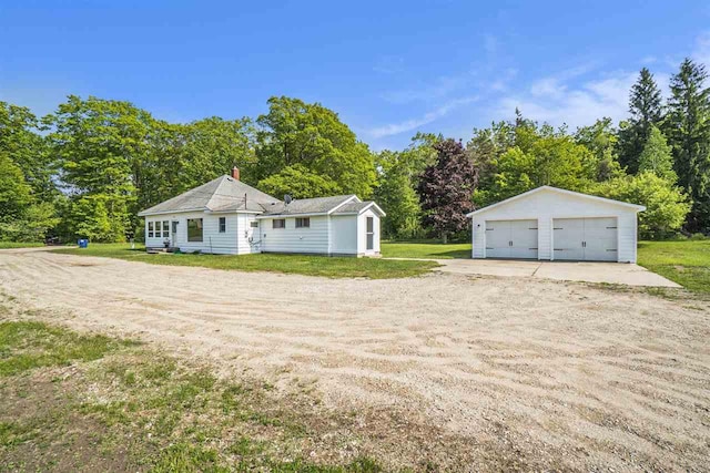 5791 Lebaron St, Levering, MI 49755 - view of front of home featuring a garage, an outdoor structure, a front yard, and view of wooded area