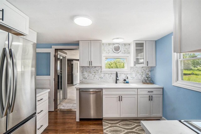 5791 Lebaron St, Levering, MI 49755 - kitchen with appliances with stainless steel finishes, a sink, decorative backsplash, and dark wood-type flooring