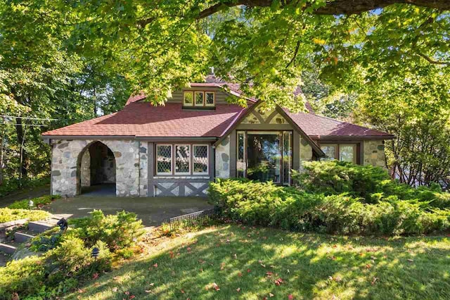 316 Park Ave, Charlevoix, MI 49727 - view of front facade with stone siding and a front lawn