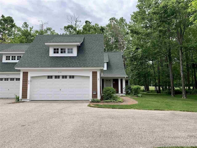 4162 Pinehurst Ln Unit 29, Harbor Springs, MI 49740 - view of front of house with driveway, a garage, a front lawn, and a shingled roof