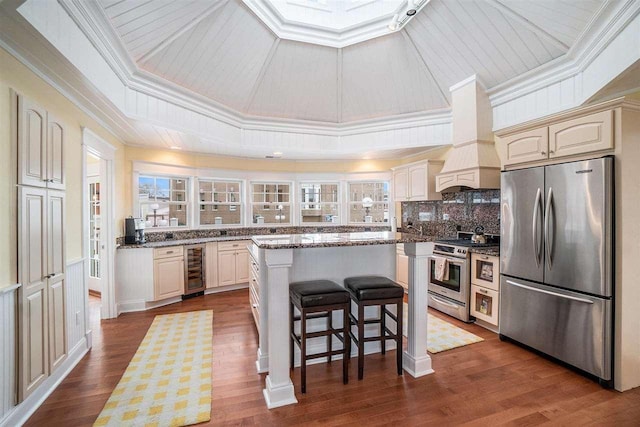 195 E Main St Unit 5, Harbor Springs, MI 49740 - kitchen with stainless steel appliances, wine cooler, a kitchen island, a breakfast bar area, and backsplash