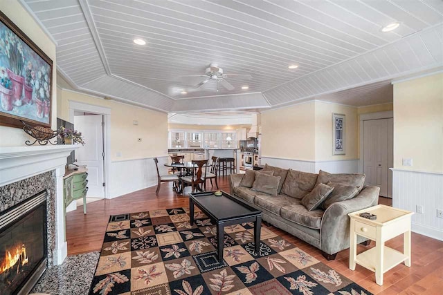 195 E Main St Unit 5, Harbor Springs, MI 49740 - living area featuring a glass covered fireplace, wood finished floors, wainscoting, ceiling fan, and crown molding