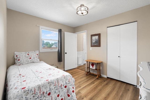 1105 Grant St, Charlevoix, MI 49720 - bedroom featuring light wood finished floors, a closet, and a textured ceiling