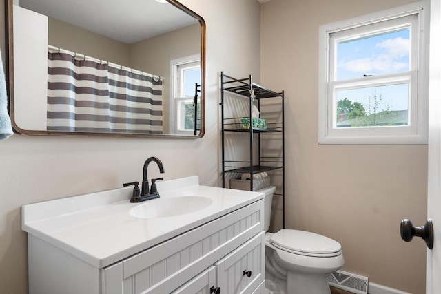 1105 Grant St, Charlevoix, MI 49720 - full bath featuring plenty of natural light, vanity, toilet, and baseboards