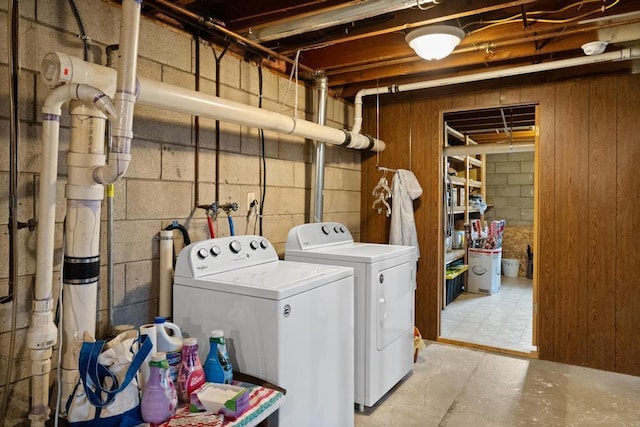 1105 Grant St, Charlevoix, MI 49720 - laundry room featuring washer and clothes dryer, wood walls, and concrete block wall