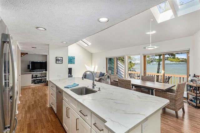 3480 Lakeside Dr N Unit 35, Petoskey, MI 49770 - kitchen featuring lofted ceiling, open floor plan, a sink, dark wood finished floors, and a skylight