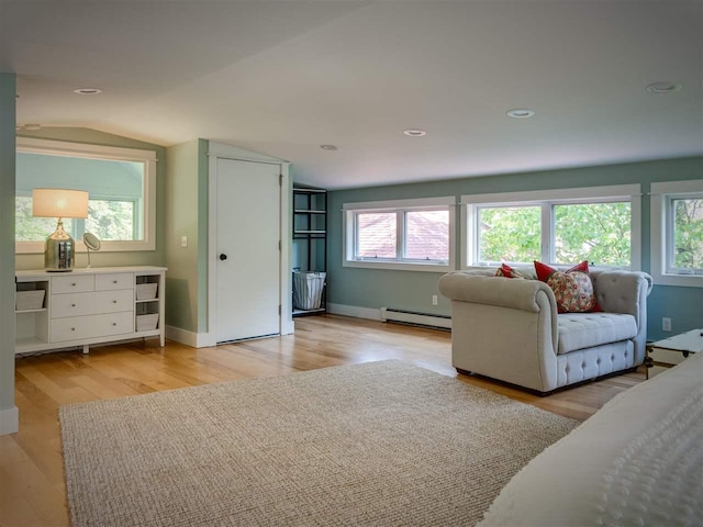 169 E Shadow Trails Rd, Boyne City, MI 49712 - living area with a baseboard radiator, light wood-style floors, vaulted ceiling, baseboards, and recessed lighting