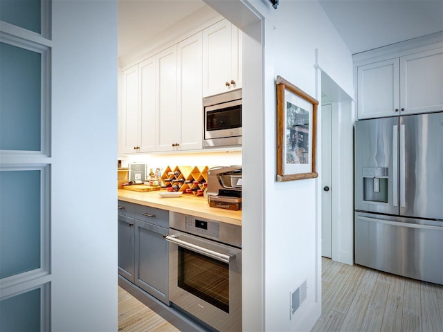 169 E Shadow Trails Rd, Boyne City, MI 49712 - kitchen featuring appliances with stainless steel finishes, light wood-type flooring, white cabinetry, and gray cabinets