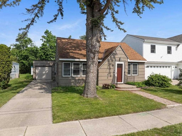 1029 Howard St, Petoskey, MI 49770 - view of front facade featuring a garage, driveway, a front yard, and roof with shingles
