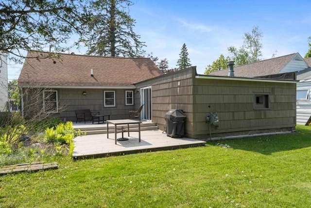 1029 Howard St, Petoskey, MI 49770 - back of property featuring a lawn, roof with shingles, and a wooden deck