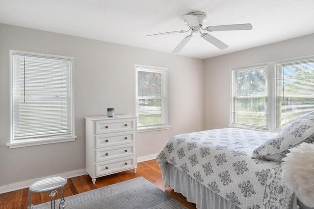 1029 Howard St, Petoskey, MI 49770 - bedroom featuring multiple windows, baseboards, wood finished floors, and ceiling fan