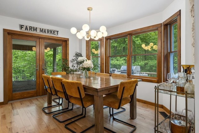 1367 Zink Rd, Boyne City, MI 49712 - dining area featuring a chandelier, light wood-style floors, baseboards, and french doors