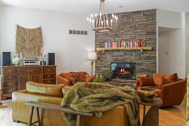 1367 Zink Rd, Boyne City, MI 49712 - living room with light wood finished floors, a chandelier, and a fireplace