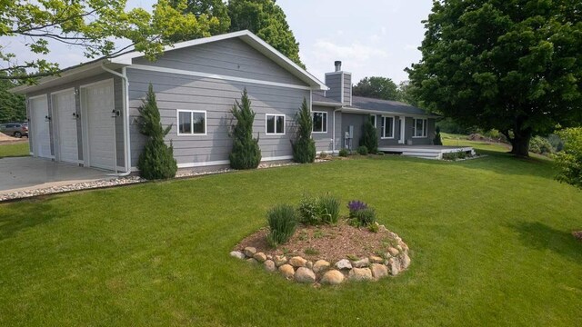8512 Dutchman Bay Rd, East Jordan, MI 49727 - back of property with a chimney, a yard, and a detached garage