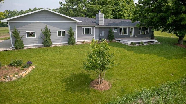 8512 Dutchman Bay Rd, East Jordan, MI 49727 - rear view of property featuring a chimney and a yard