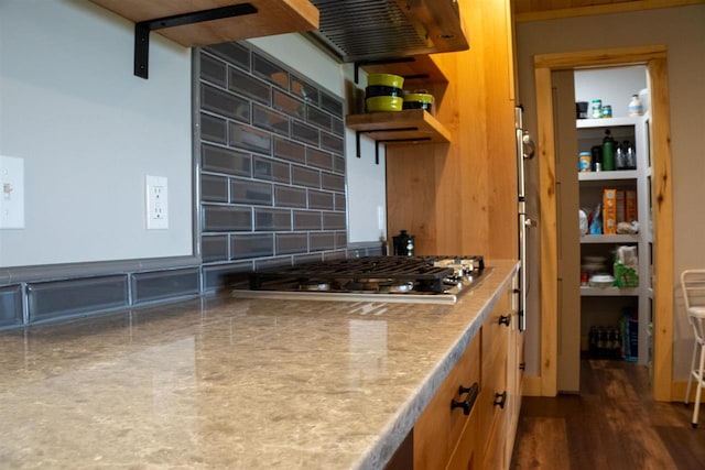 8512 Dutchman Bay Rd, East Jordan, MI 49727 - kitchen with stainless steel gas stovetop, tasteful backsplash, extractor fan, and brown cabinets
