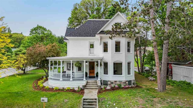 503 N Bridge St, Bellaire, MI 49615 - view of front facade with a porch, a front yard, and a shingled roof