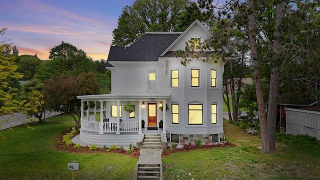 503 N Bridge St, Bellaire, MI 49615 - view of front of home featuring covered porch, a yard, and a shingled roof