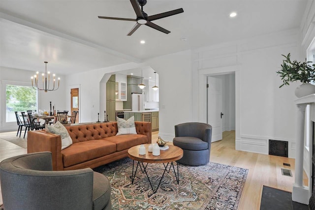 503 N Bridge St, Bellaire, MI 49615 - living area with ceiling fan, a chandelier, light wood-type flooring, arched walkways, and recessed lighting