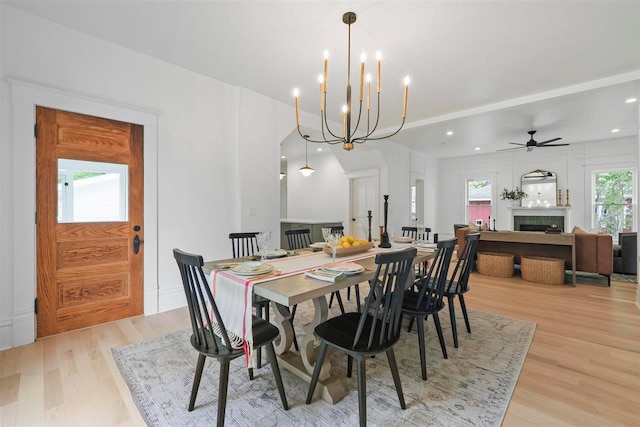 503 N Bridge St, Bellaire, MI 49615 - dining space with light wood-style flooring, a fireplace, a ceiling fan, recessed lighting, and a chandelier