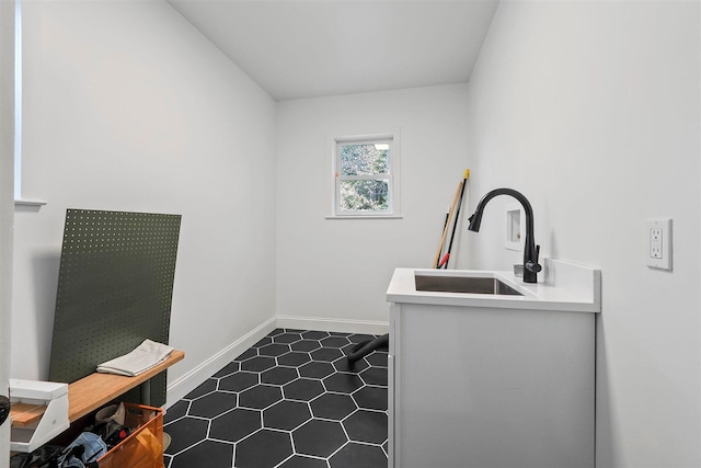503 N Bridge St, Bellaire, MI 49615 - laundry room featuring a sink, dark tile patterned flooring, and baseboards