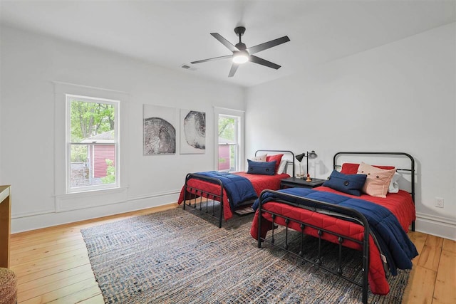 503 N Bridge St, Bellaire, MI 49615 - bedroom featuring hardwood / wood-style flooring, multiple windows, and a ceiling fan