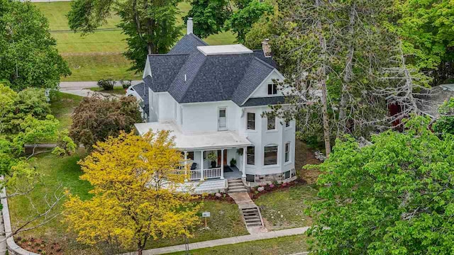 503 N Bridge St, Bellaire, MI 49615 - view of front of house with roof with shingles, a porch, a chimney, stucco siding, and stairs
