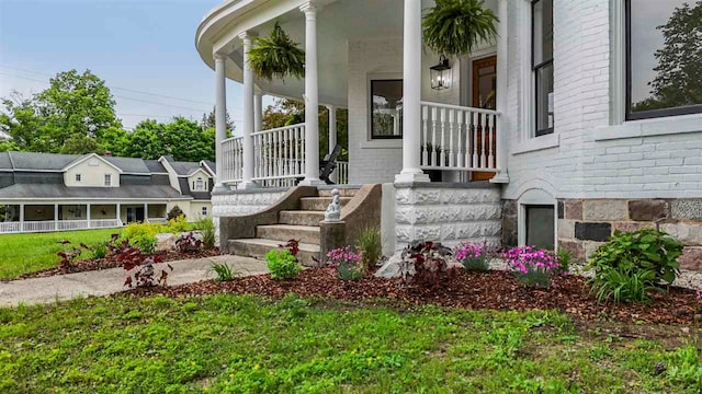 503 N Bridge St, Bellaire, MI 49615 - property entrance with a porch and brick siding