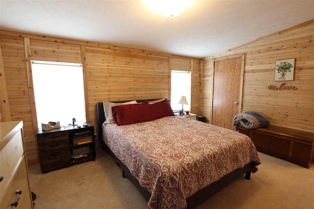 6685 M-66 Hwy, Charlevoix, MI 49720 - bedroom with vaulted ceiling, light carpet, wood walls, and a closet