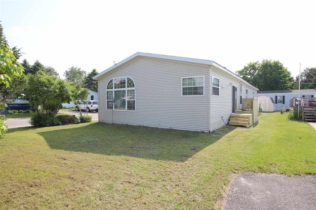 6685 M-66 Hwy, Charlevoix, MI 49720 - view of property exterior featuring a storage unit and a lawn