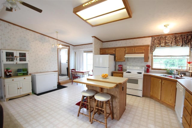 6685 M-66 Hwy, Charlevoix, MI 49720 - kitchen featuring white appliances, under cabinet range hood, wallpapered walls, light floors, and crown molding