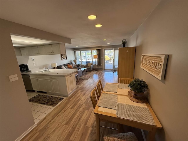 107 Belvedere Ave Unit A-3, Charlevoix, MI 49720 - kitchen with light wood finished floors, recessed lighting, open floor plan, light countertops, and stainless steel dishwasher