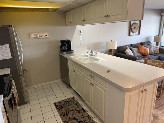 107 Belvedere Ave Unit A-3, Charlevoix, MI 49720 - kitchen featuring a peninsula, appliances with stainless steel finishes, open floor plan, light tile patterned floors, and light countertops
