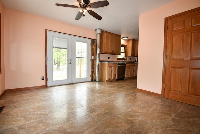 2335 Lone Pine Rd, Gaylord, MI 49735 - kitchen featuring stainless steel dishwasher, brown cabinetry, ceiling fan, stone finish flooring, and dark countertops