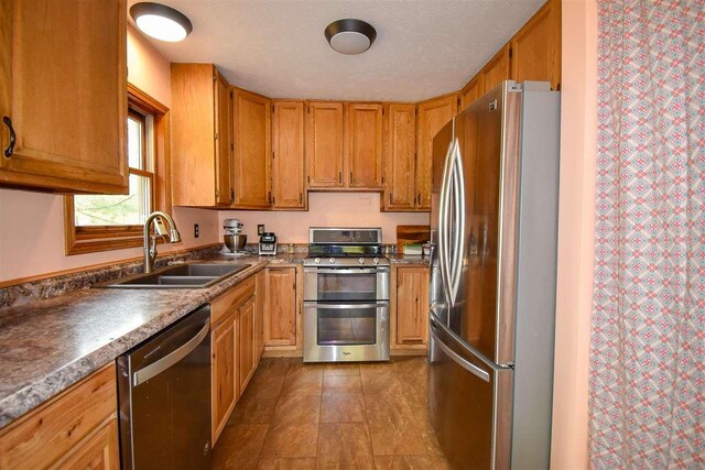 2335 Lone Pine Rd, Gaylord, MI 49735 - kitchen with appliances with stainless steel finishes and brown cabinetry