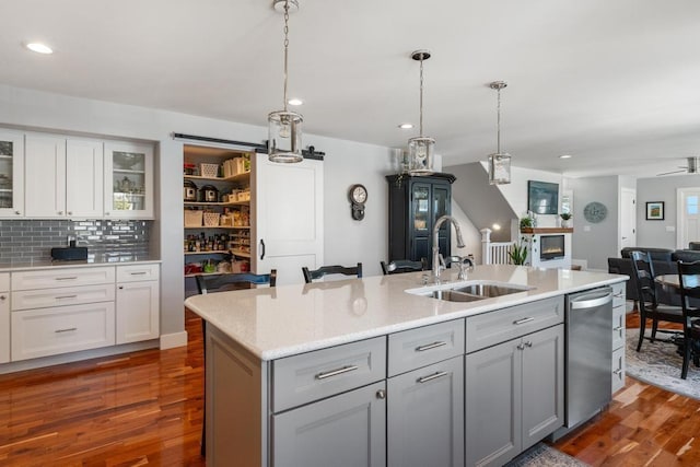 135 Beaubien Ave, Petoskey, MI 49770 - kitchen featuring dishwasher, dark wood-style floors, a center island with sink, open floor plan, and white cabinets