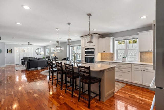 135 Beaubien Ave, Petoskey, MI 49770 - kitchen with double oven, light countertops, tasteful backsplash, hardwood / wood-style flooring, and recessed lighting