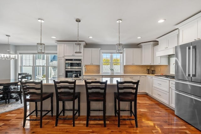 135 Beaubien Ave, Petoskey, MI 49770 - kitchen with stainless steel appliances, tasteful backsplash, a breakfast bar, a center island with sink, and recessed lighting
