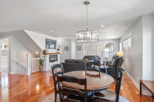 135 Beaubien Ave, Petoskey, MI 49770 - dining room with wood finished floors, a chandelier, recessed lighting, and a glass covered fireplace