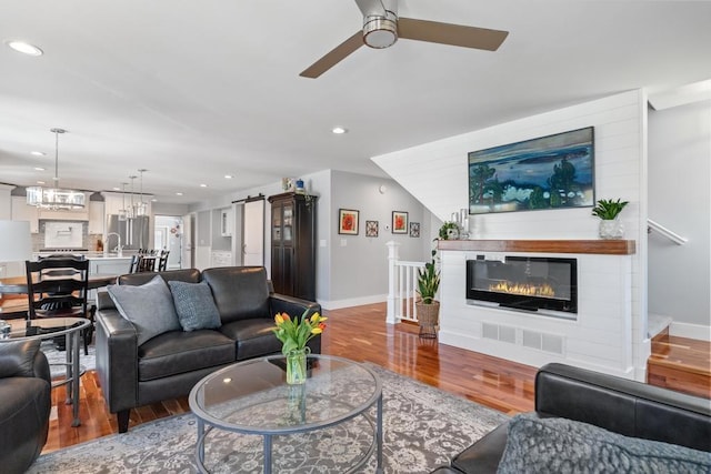 135 Beaubien Ave, Petoskey, MI 49770 - living room with a ceiling fan, wood finished floors, a barn door, recessed lighting, and a glass covered fireplace