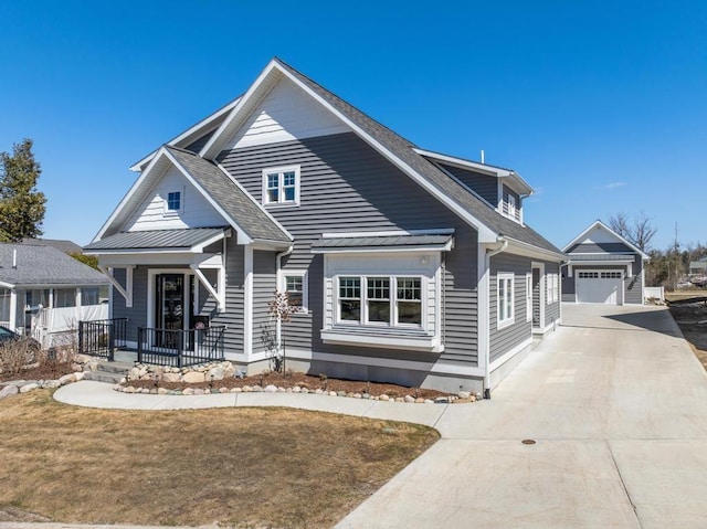135 Beaubien Ave, Petoskey, MI 49770 - view of front facade with a porch, an outbuilding, driveway, a garage, and a shingled roof